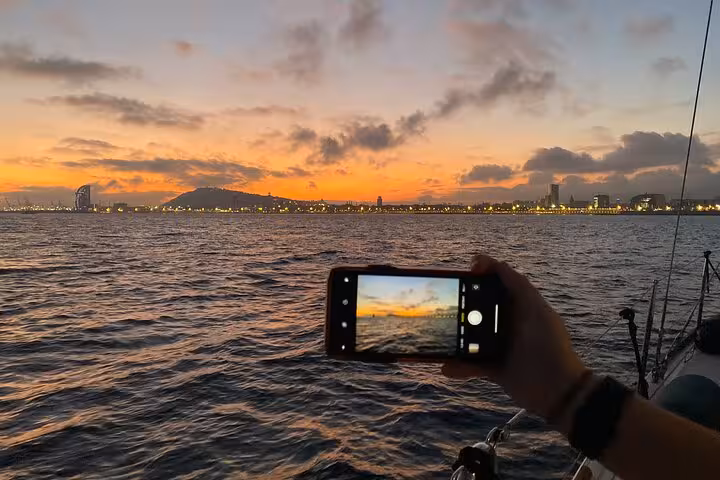 Capturing Barcelona skyline at sunset from a private sailing boat, ideal for open bar cruise with saxophone
