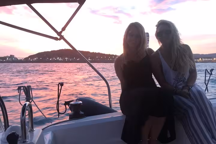Couple relaxing on deck during a Barcelona sunset private sailing experience with open bar and snacks
