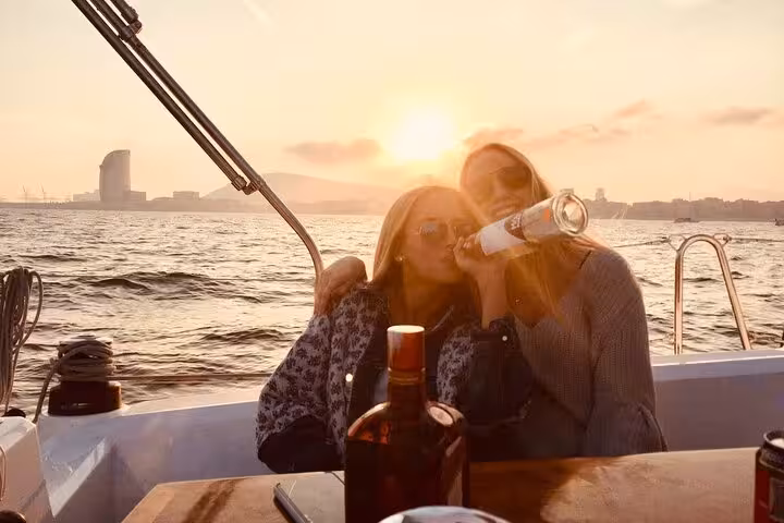 Couple enjoying open bar drinks on a private sunset sailing tour in Barcelona with sea views