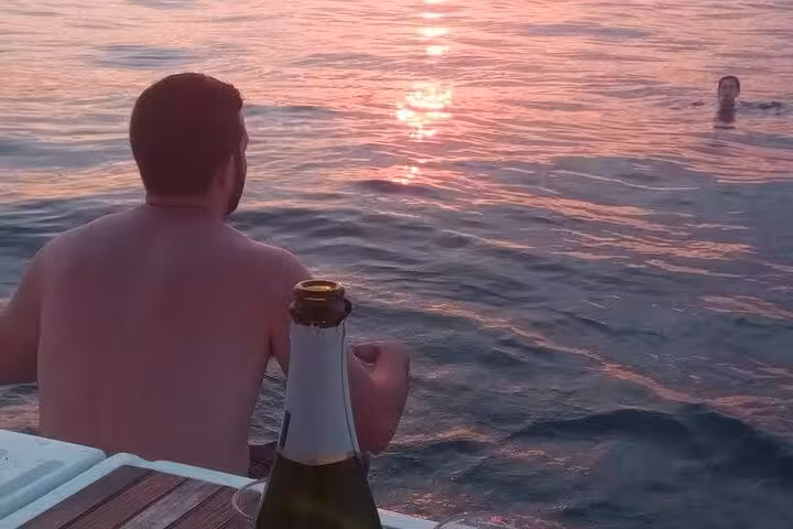 Guest relaxing on a Barcelona sunset private sail with open bar drinks on deck, Mediterranean sea views