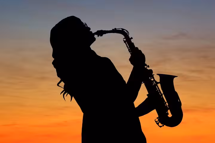Silhouette of saxophonist at sunset on a private Barcelona sailing tour with live music and open bar