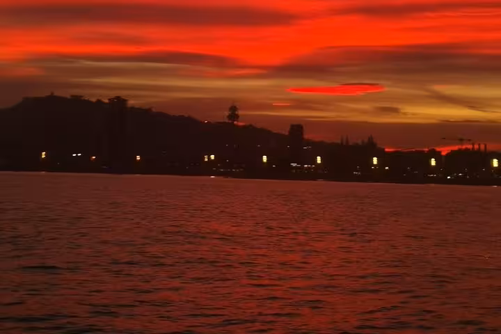 Fiery Barcelona sunset over the Mediterranean on a private sailing tour with live Spanish guitar and open bar