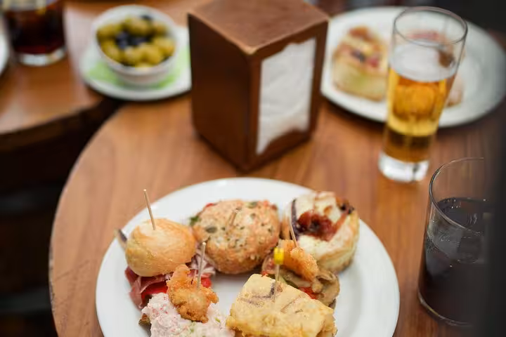 Assorted pintxos and tapas with beer on a Barcelona tapas tour, authentic local food and wine tasting