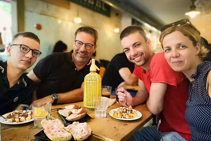 Group enjoying tapas at a cozy Barcelona restaurant, perfect for a private tour including Sagrada Familia and Park Güell.