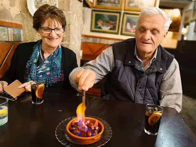 Couple enjoys a lively Barcelona tapas experience with flaming dish and drinks on a private highlights and secrets tour.
