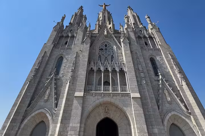 Majestic view of the Tibidabo Basilica facade against a clear blue sky on the Barcelona guided city tour.