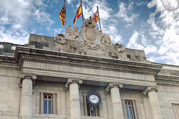 Historic building with flags and clock in Barcelona, visited on a small group walking tour.