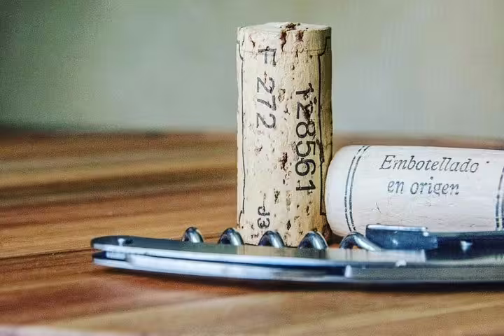 Wine corks and opener on a wooden table, symbolizing the wine tasting experience in the Barcelona tour.