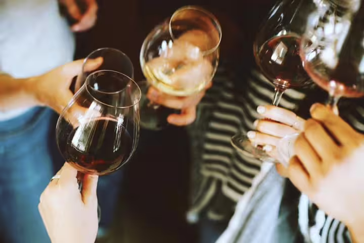 Group enjoying wine tasting with red and white wines, ideal for a Barcelona culinary tour experience.