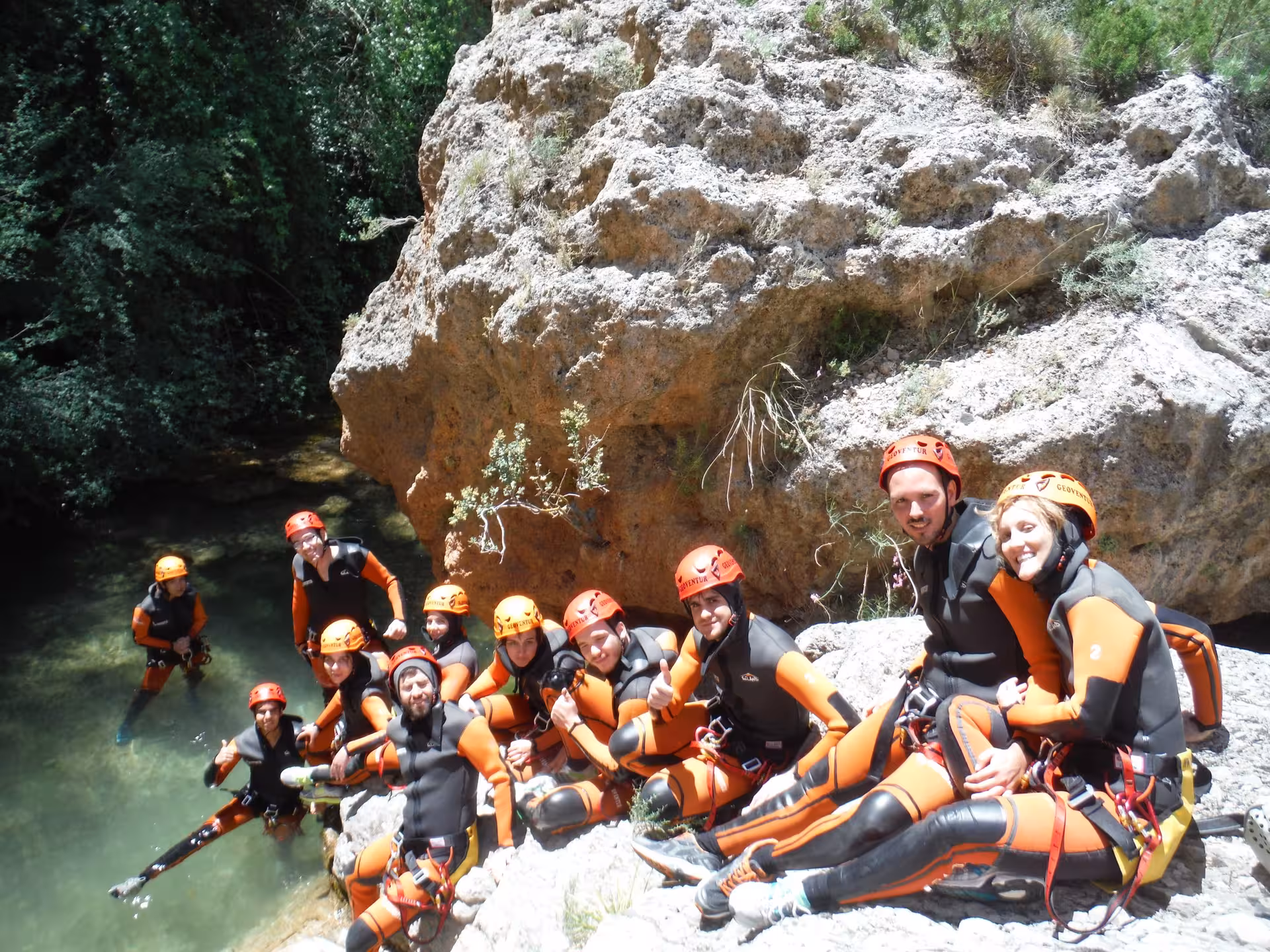 Grupo con neopreno y casco en poza del barranco acuático de Riodeva, Teruel, aventura de barranquismo guiado