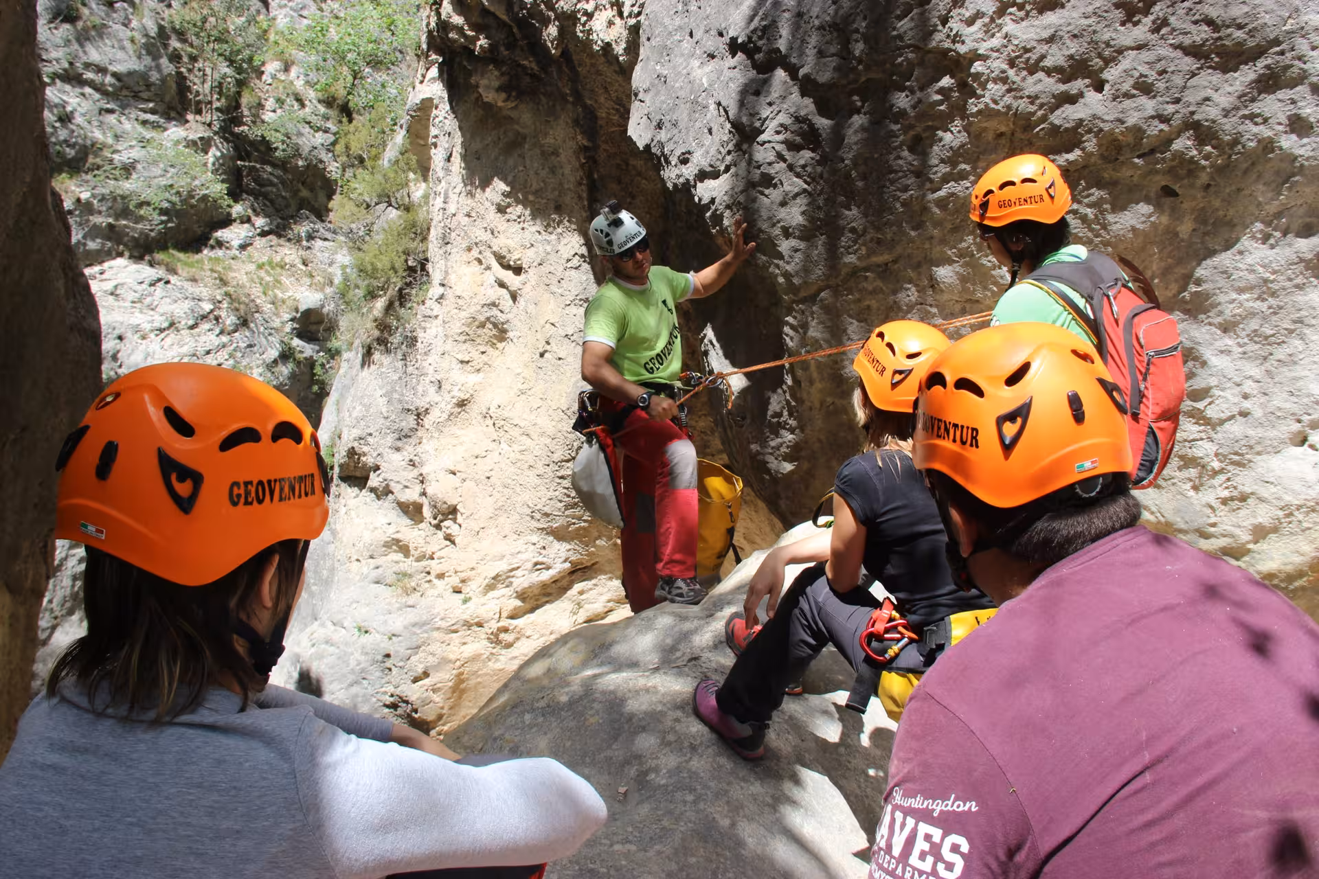 Guía de barranquismo explica maniobras con cuerda a un grupo en el barranco seco de Aliaga, Teruel