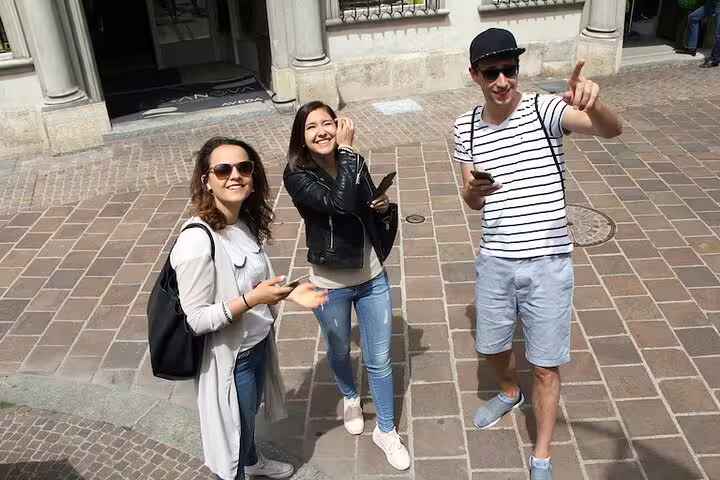 Friends using phones on Basel Old Town streets during a self-guided scavenger hunt sightseeing tour