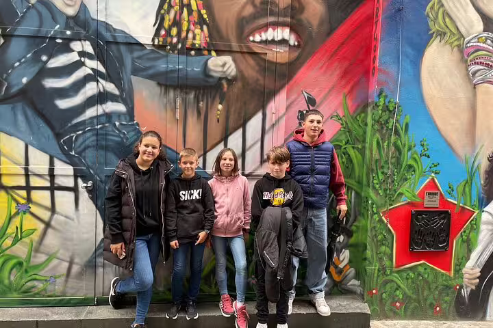 Family posing by colorful street art mural on Basel scavenger hunt self-guided tour, exploring hidden city sights