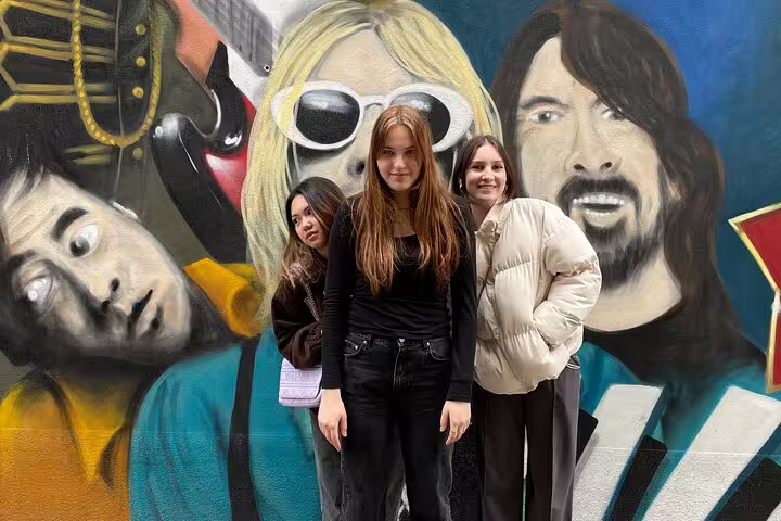 Friends pose by a colorful music street art mural on the Basel self-guided scavenger hunt walking tour