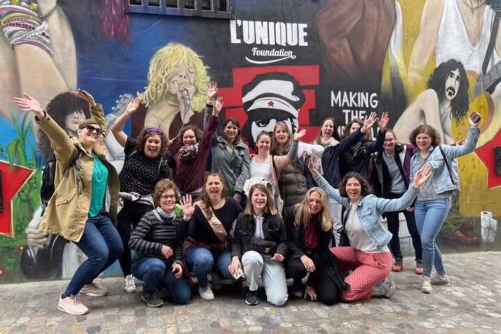 Group celebrating at Basel street art mural stop on scavenger hunt self-guided tour, fun teamwork and sightseeing