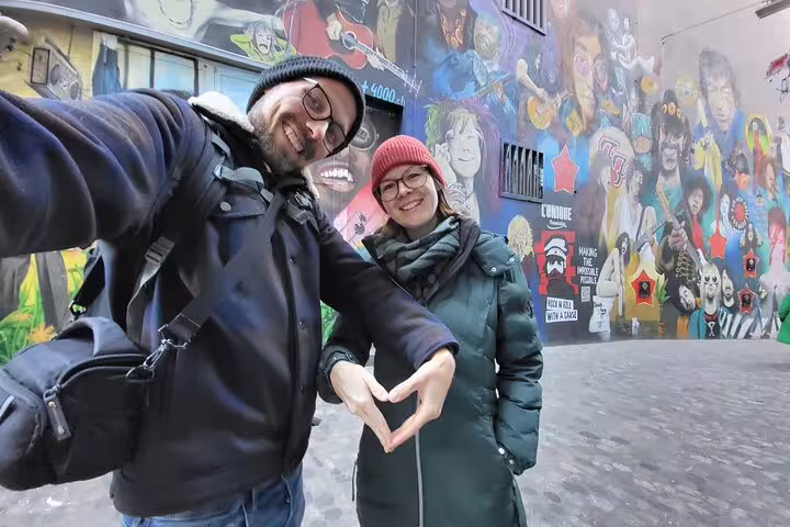 Couple selfie at Basel street art alley during self-guided scavenger hunt tour, discovering murals and city highlights