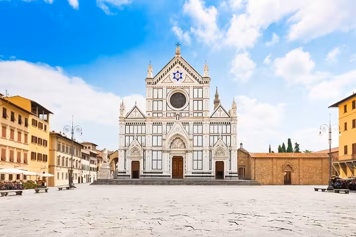 The stunning Basilica of Santa Croce stands illuminated under a clear sky in Florence, Italy.