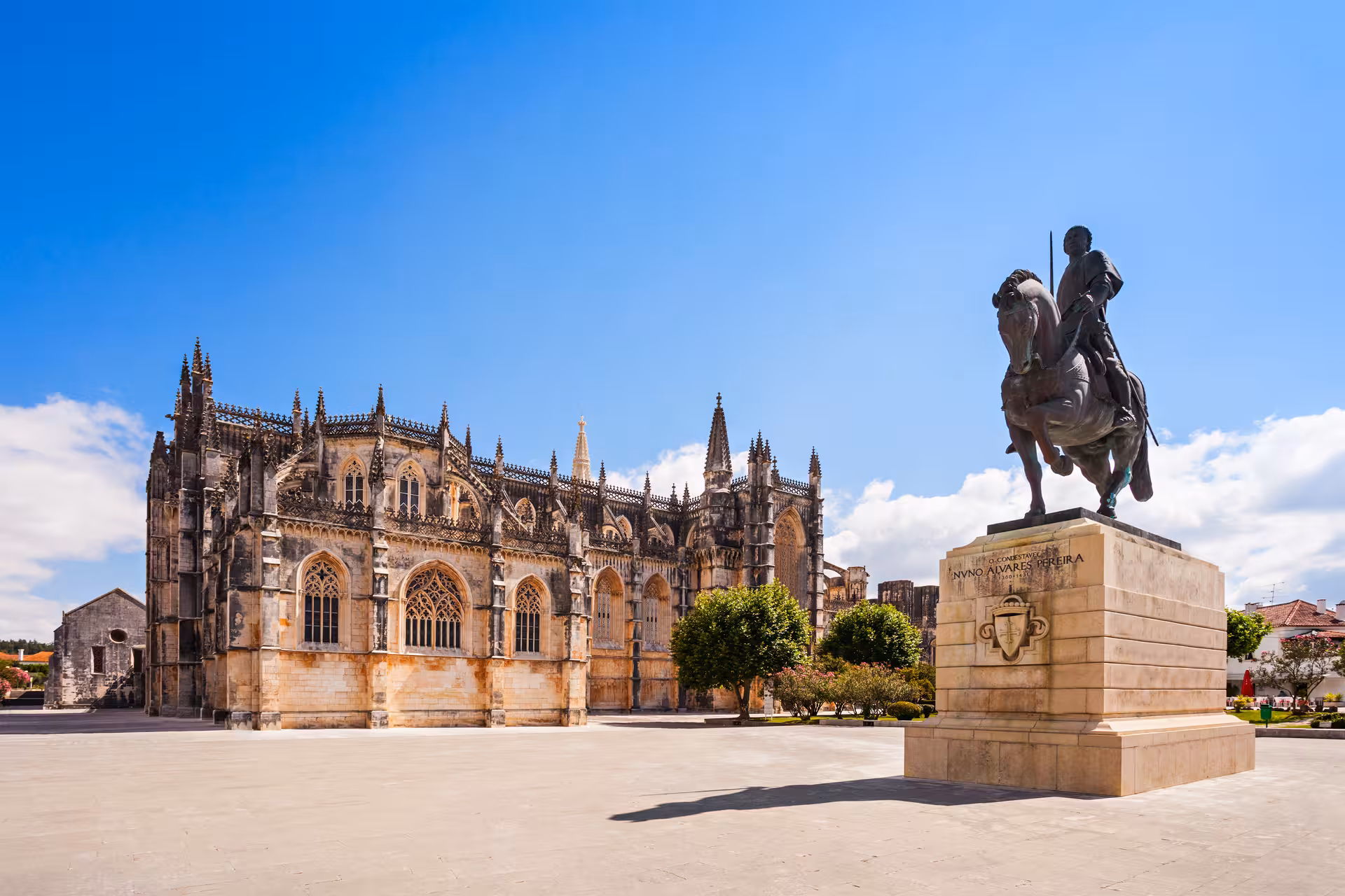 Batalha Monastery and equestrian statue under a clear sky, a must-see on the Fátima and Óbidos tour.
