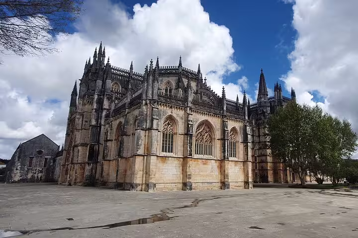 Gothic architecture of Batalha Monastery under a blue sky, part of the Fátima, Batalha, Nazaré & Óbidos private tour from Lisbon.