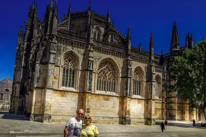 Tourists enjoying the stunning Gothic architecture of Batalha Monastery on a full-day private tour from Lisbon to Óbidos, Nazaré, Alcobaça, and Fátima.