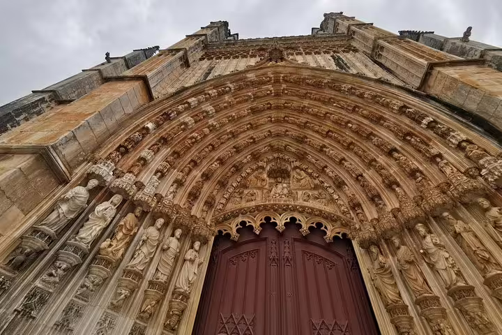Gothic architecture of Batalha Monastery facade in Portugal, a highlight of the Óbidos, Nazaré, Alcobaça, and Fátima tour from Lisbon.