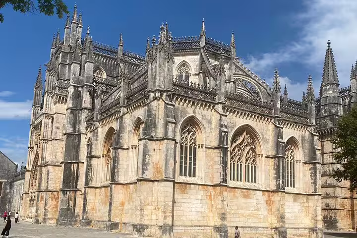 Majestic Gothic architecture of Batalha Monastery under a clear sky, featuring intricate design and historical significance.