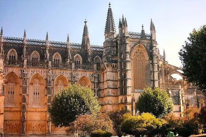 Majestic Batalha Monastery showcasing intricate Gothic architecture surrounded by lush gardens.
