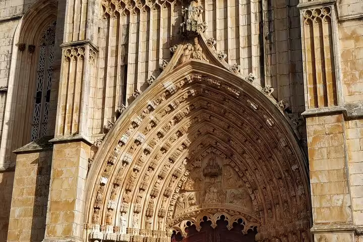 Ornate Gothic entrance of Batalha Monastery, highlighting intricate stonework on a private day tour to Fatima, Nazaré, and Obidos.
