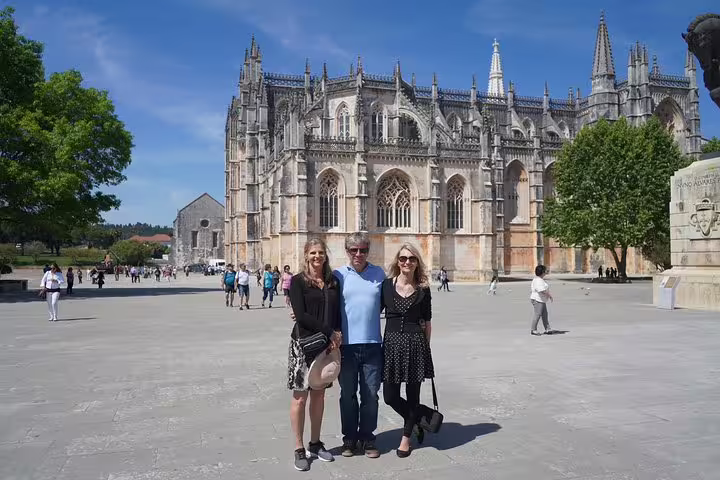 Tourists enjoying a sunny day at the Batalha Monastery, a key stop on the Óbidos, Nazaré, Alcobaça, and Fátima tour from Lisbon.