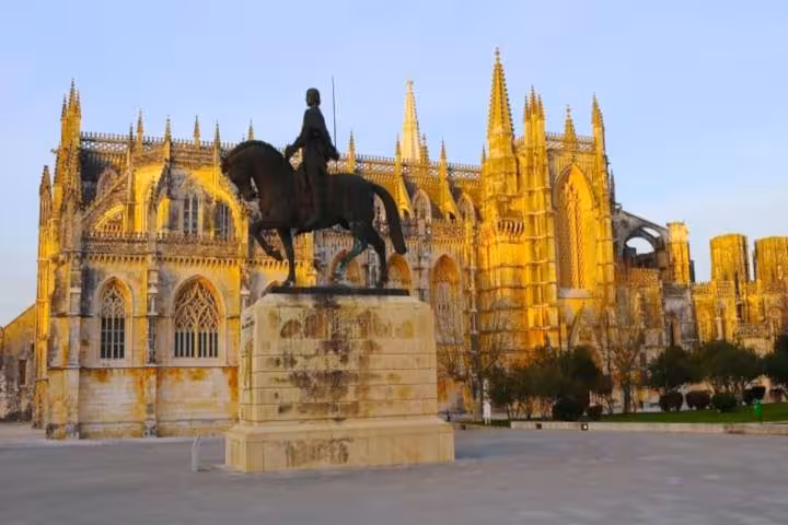 Batalha Monastery with equestrian statue at sunrise, a key highlight on the private tour of Fátima, Batalha, Nazaré, and Óbidos.