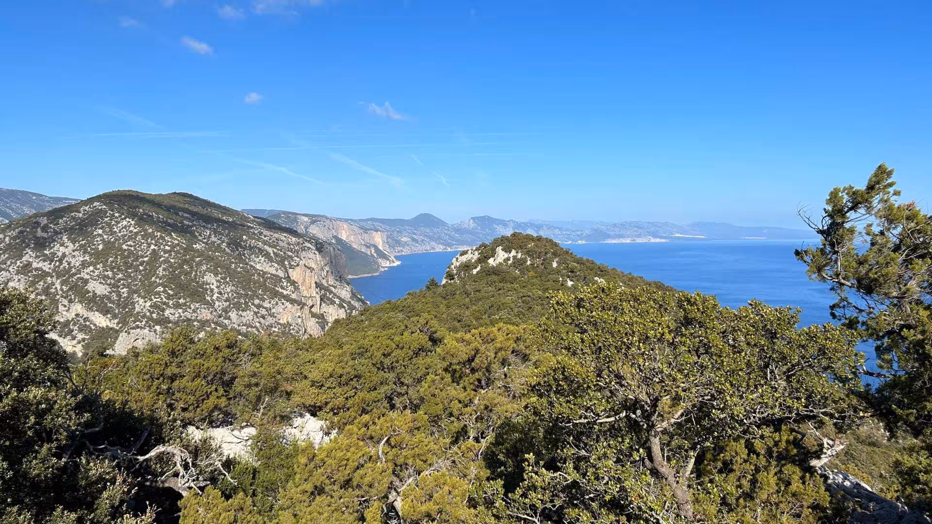 Scenic view of lush green hills meeting the azure Mediterranean Sea on the Baunei buggy tour to Punta Salinas.