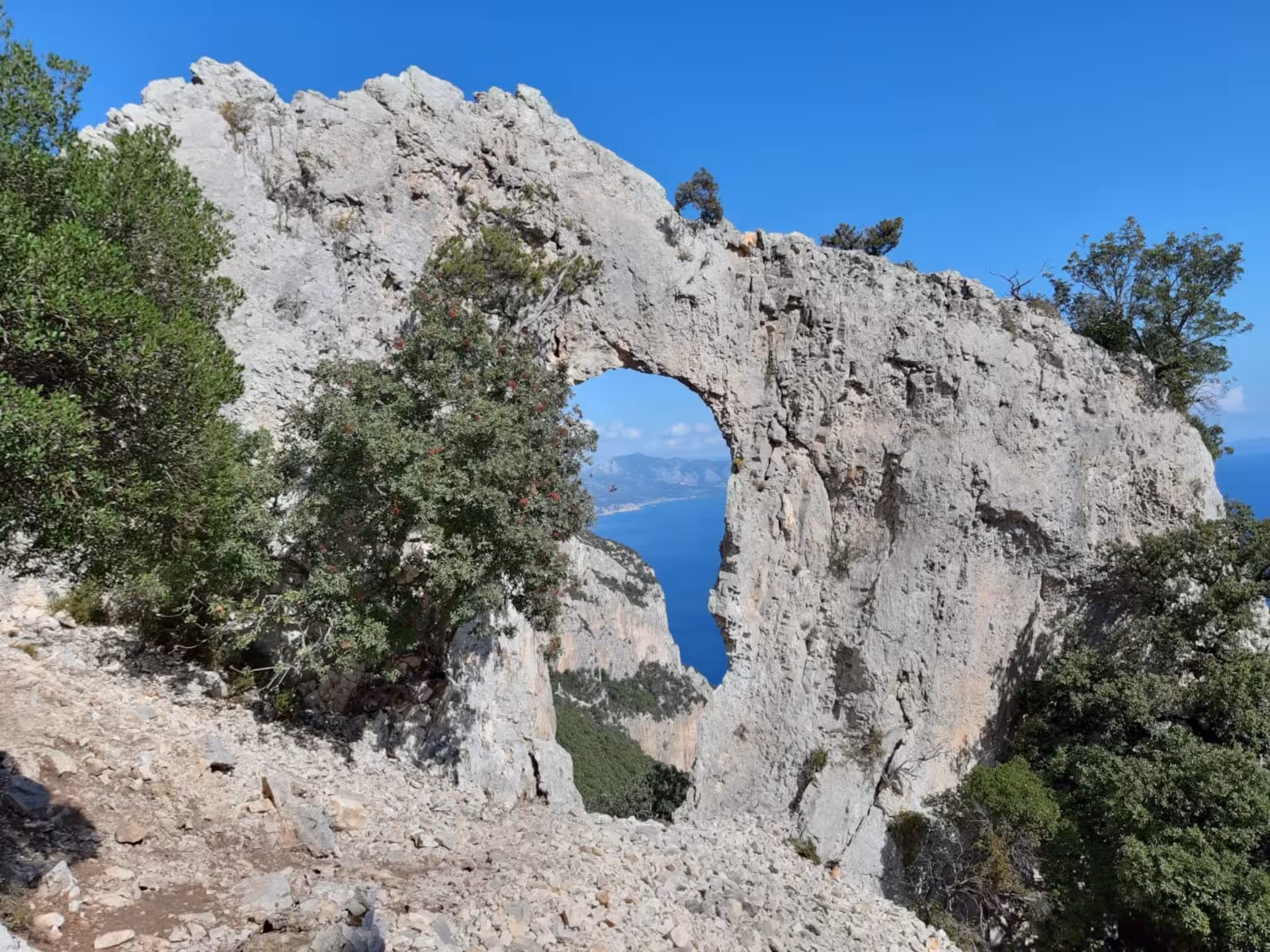 Natural rock arch formation with breathtaking sea views, a highlight of the trek from Baunei to Cala Mariolu.