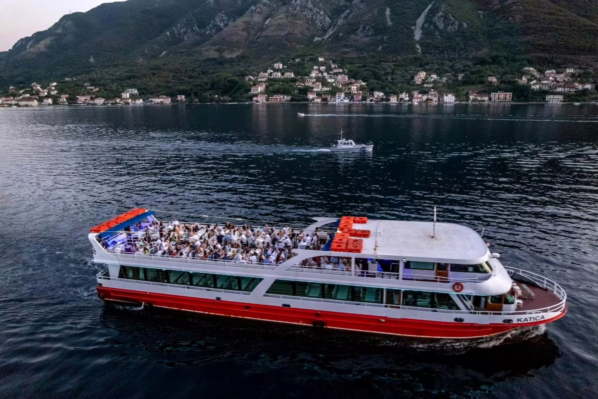 Cruise boat sailing the Bay of Kotor with mountain views, part of the Our Lady of the Rocks tour from Dubrovnik