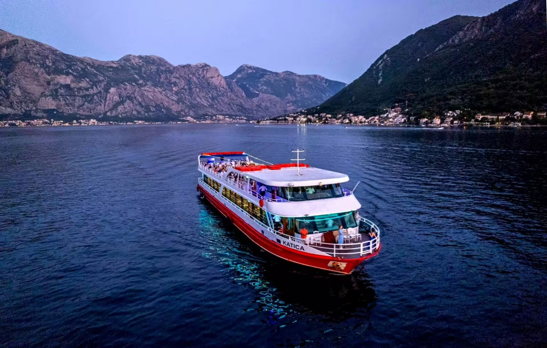 Evening Bay of Kotor cruise boat from Dubrovnik, sailing past Montenegro fjord views toward Our Lady of the Rocks