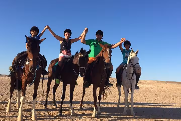 Group of riders celebrate on horseback near Hurghada on one-hour beach horse riding experience with transfer included