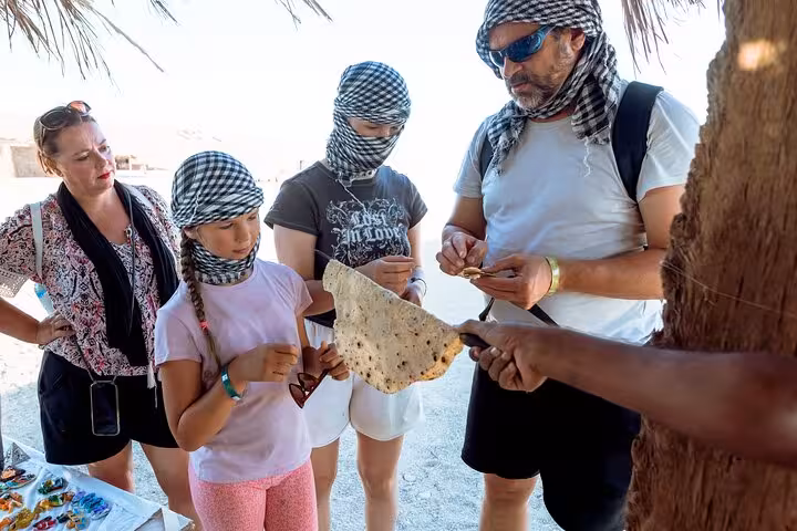 Bedouin camp stop on Sharm El Sheikh desert safari, guests tasting flatbread before ATV quad and camel ride