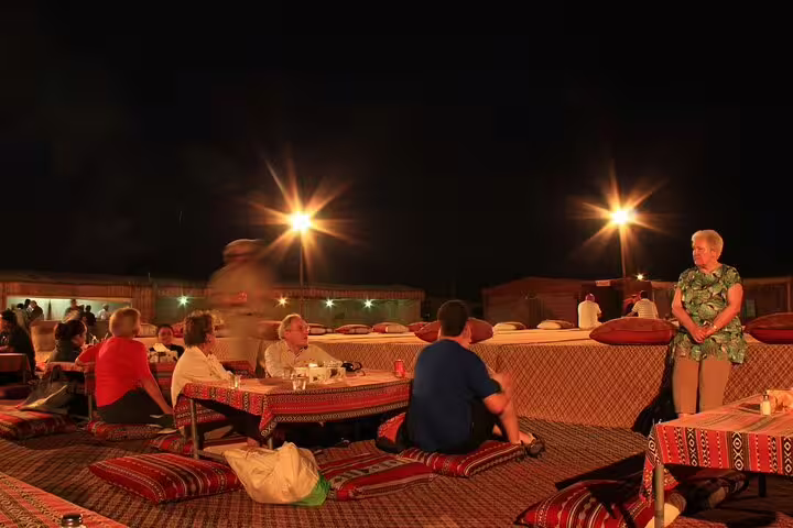 Bedouin-style dinner seating under lights at Marsa Alam Jeep safari camp with evening show atmosphere