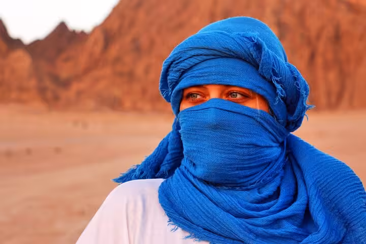 Bedouin guide in blue headscarf in Sinai desert, Sharm El Sheikh quad safari with dinner show experience