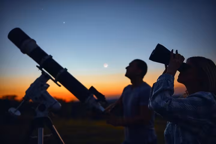 Guests stargazing at sunset with telescope in Marsa Alam desert on Bedouin night jeep safari with dinner