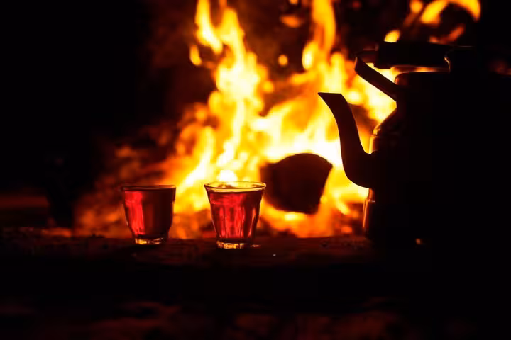 Bedouin tea served by campfire in Hurghada desert during stargazing jeep tour with optional ATV