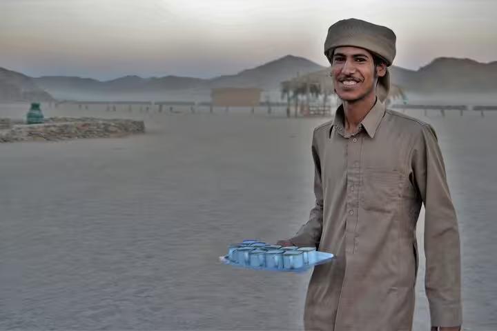 Bedouin host serving tea in the Sharm El Sheikh desert camp during a sunset or sunrise ATV quad tour