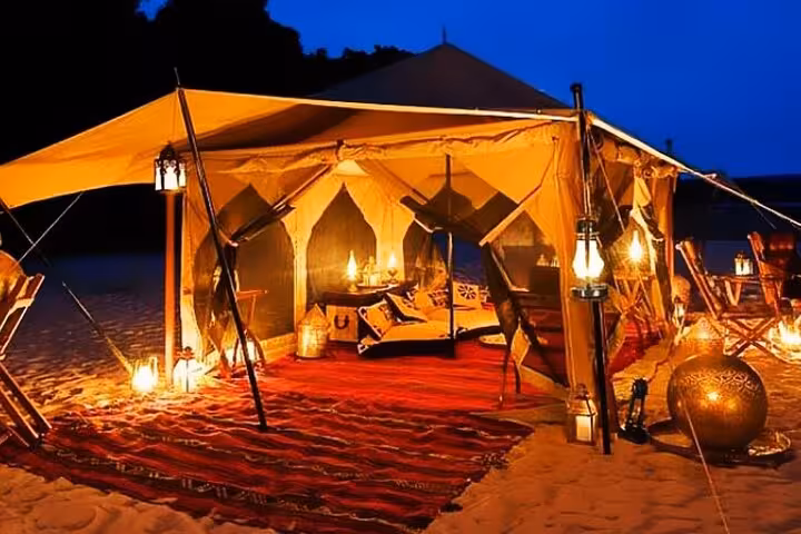 Lantern-lit Bedouin tent setup for Marsa Alam desert jeep safari dinner, traditional cushions and carpets