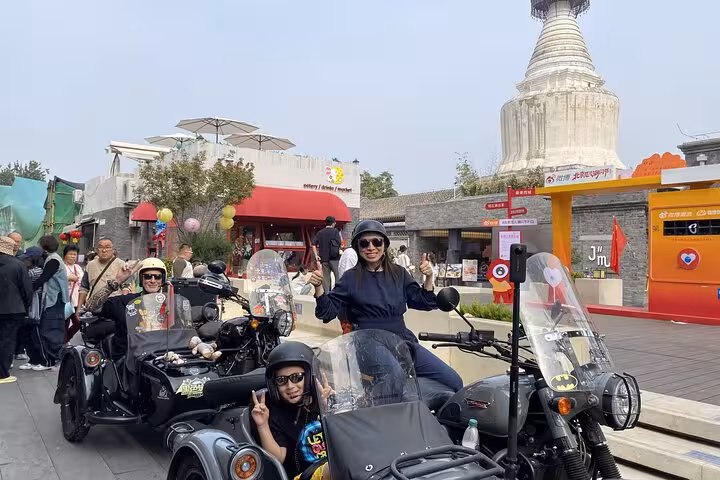 Tourists enjoy a vibrant Beijing sidecar food tour, riding sidecars past local landmarks and savoring authentic flavors.