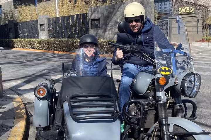 Explore Beijing's streets on a vintage sidecar motorcycle with a local guide during this unique 2-hour tour experience.