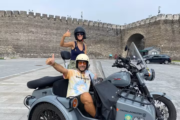 Tourists enjoy a sidecar ride beside Beijing's ancient city wall on the 2-hour sidecar tour.