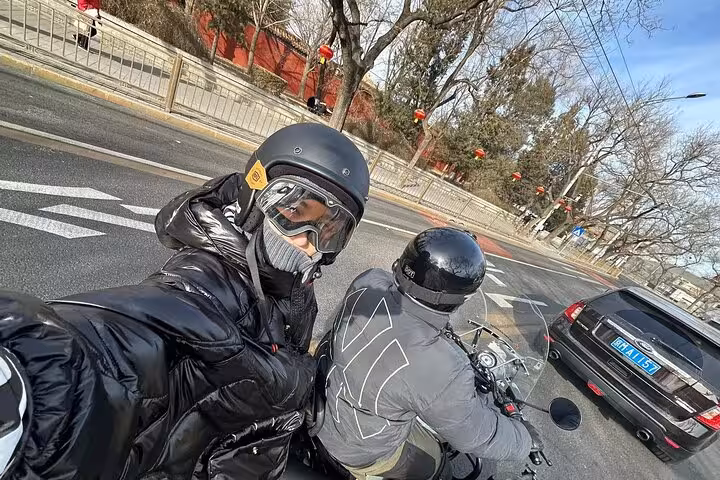 Tourists enjoying a thrilling Beijing sidecar ride on a clear day, highlighting ancient and modern cityscapes.