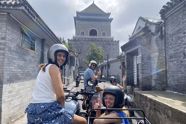 Visitors explore Beijing's historic streets near the Drum Tower on a unique sidecar tour, immersing in local culture and history.
