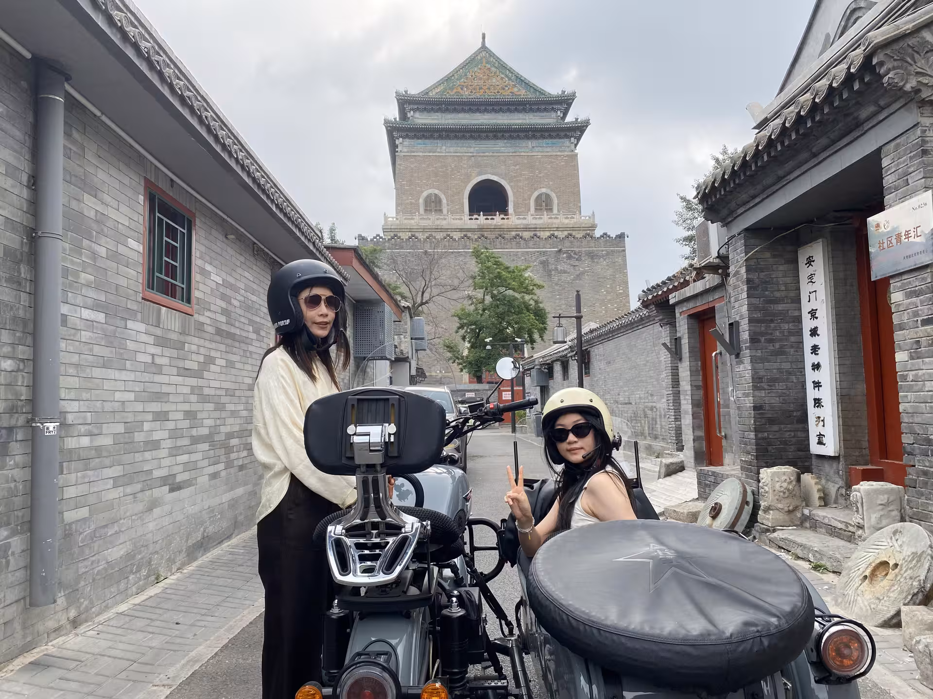Visitors on a sidecar tour in Old Beijing, exploring traditional architecture near the historic Drum Tower.