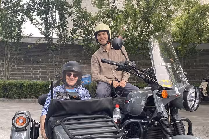 Smiling riders on a Beijing sidecar tour, exploring the city’s rich culture and scenic routes in style and comfort.