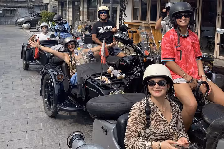 Group of tourists ready for a thrilling day tour on vintage sidecars through Beijing's historic alleys.